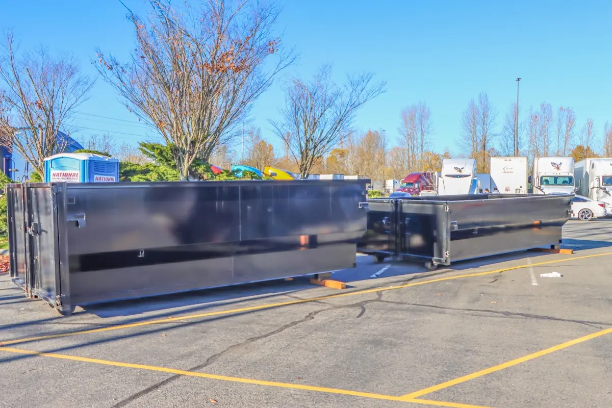Professional dumpster rental service with roll-off container on residential driveway in Brownville
